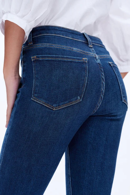 Model wearing dark blue mid-rise skinny jeans with a form-fitting silhouette and ankle-length cut.