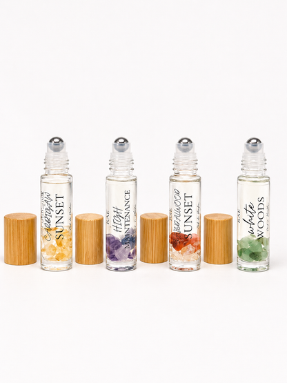 Set of four roller bottles with bamboo caps on a white background.