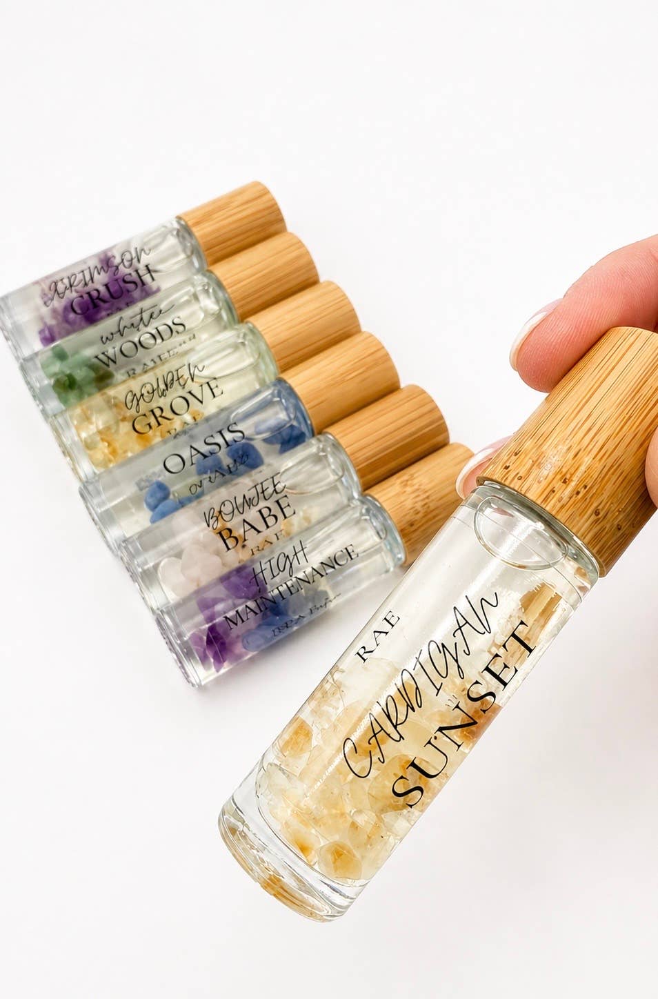Set of small glass bottles with wooden caps on a white background.