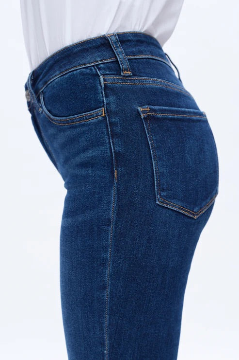 Model wearing dark blue mid-rise skinny jeans with a form-fitting silhouette and ankle-length cut.