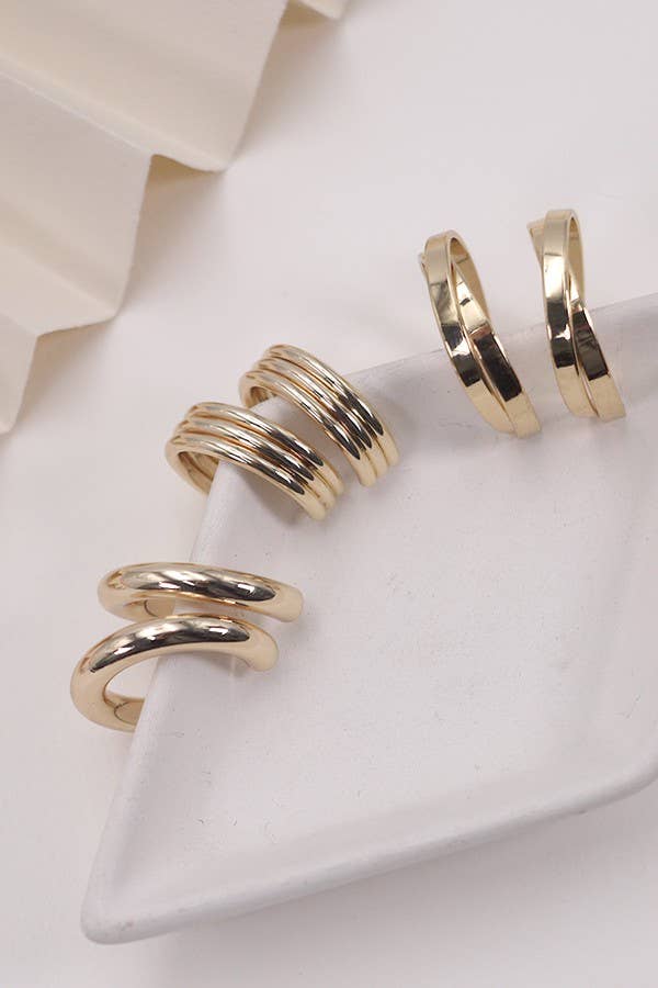 Trio of 3 different sizes of gold hoops showcased on a white surface.
