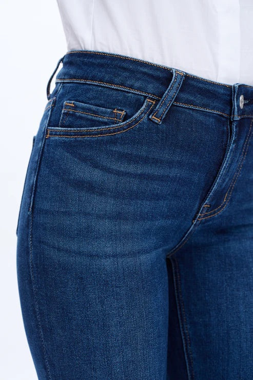 Model wearing dark blue mid-rise skinny jeans with a form-fitting silhouette and ankle-length cut.