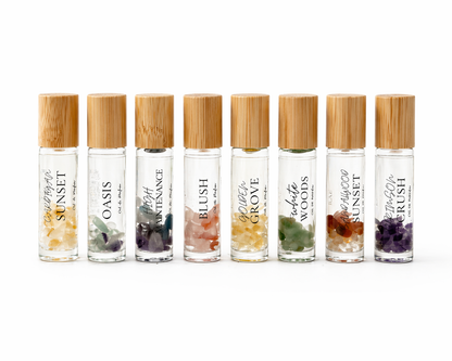 Set of eight small glass bottles with bamboo caps on a white background.