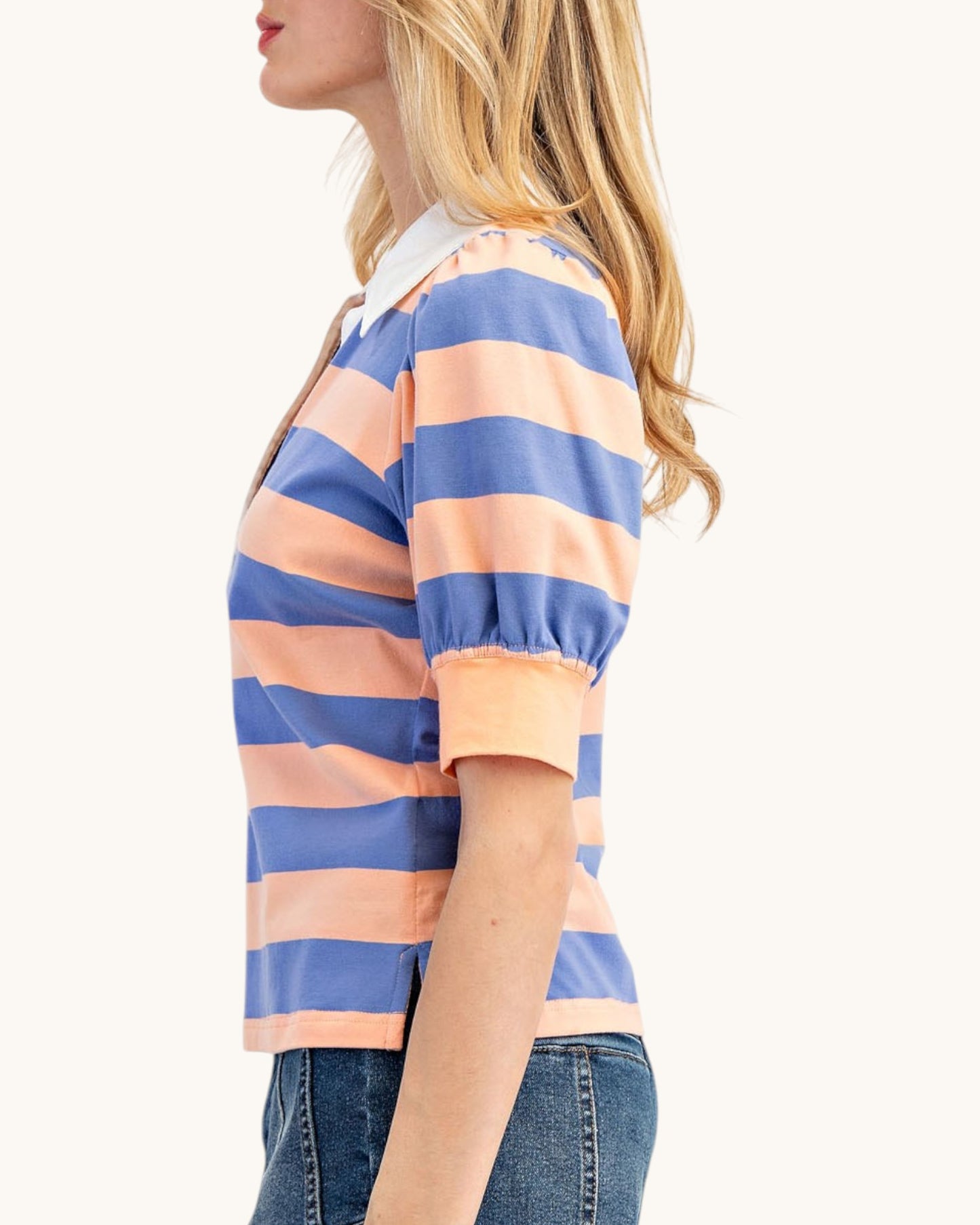 Woman wearing a striped shirt with blue and peach colors on a white background.