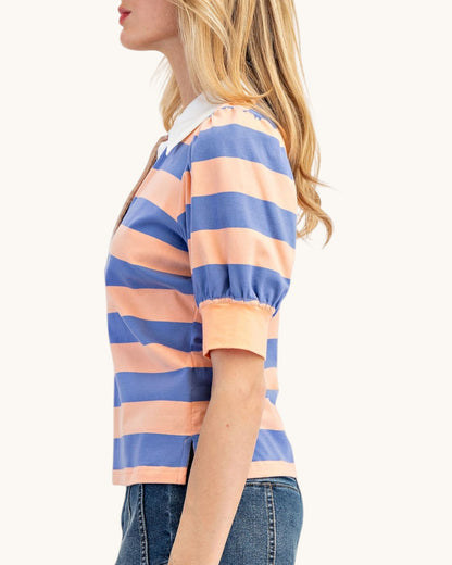 Woman wearing a striped shirt with blue and peach colors on a white background.