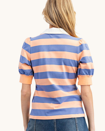 Woman wearing a blue and orange striped polo shirt on a white background.