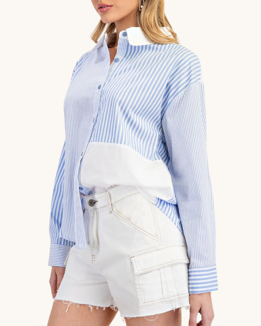 Woman wearing a blue and white striped shirt with a white top and shorts on a white background.