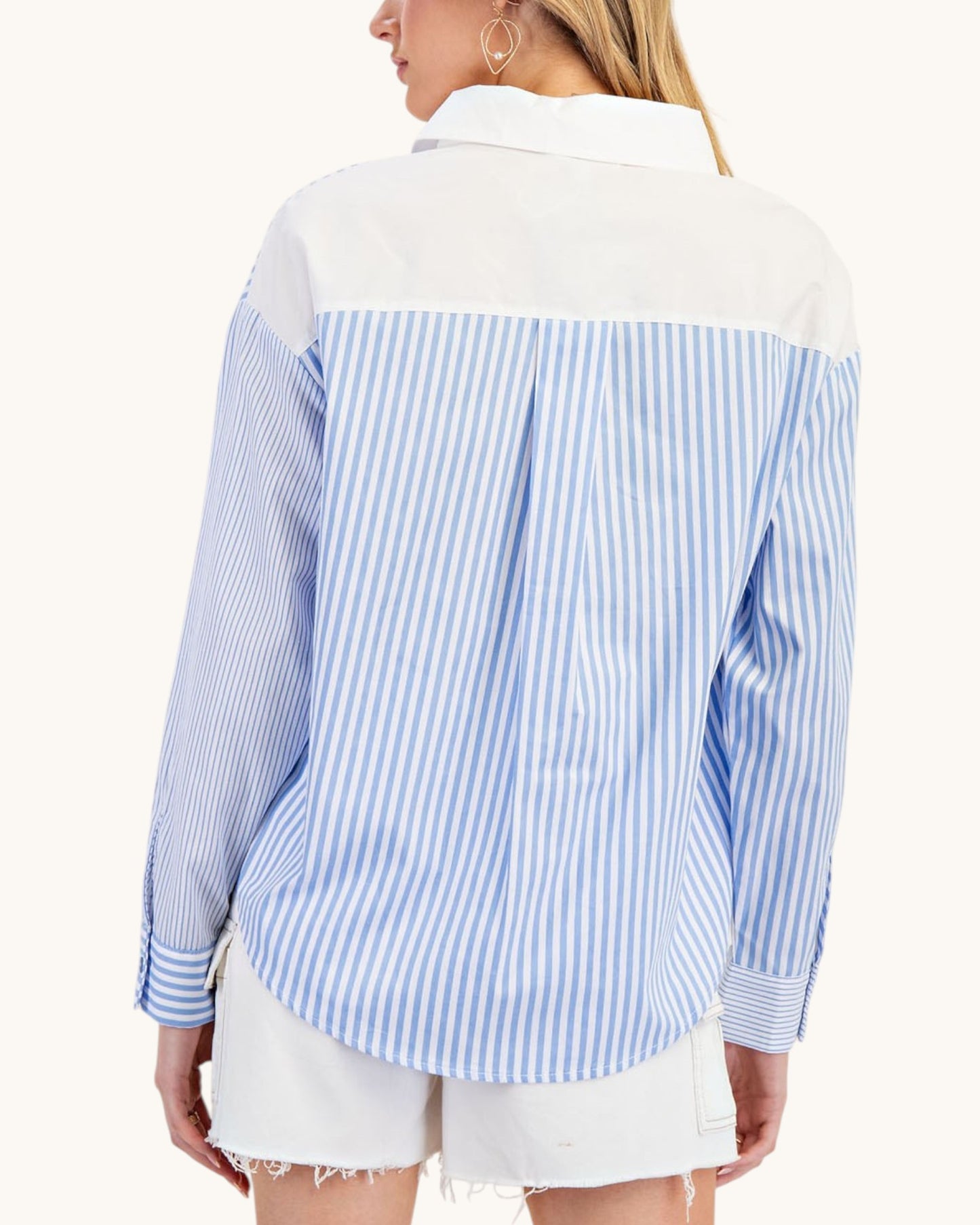 Woman wearing a blue and white striped shirt with a white collar on a white background.