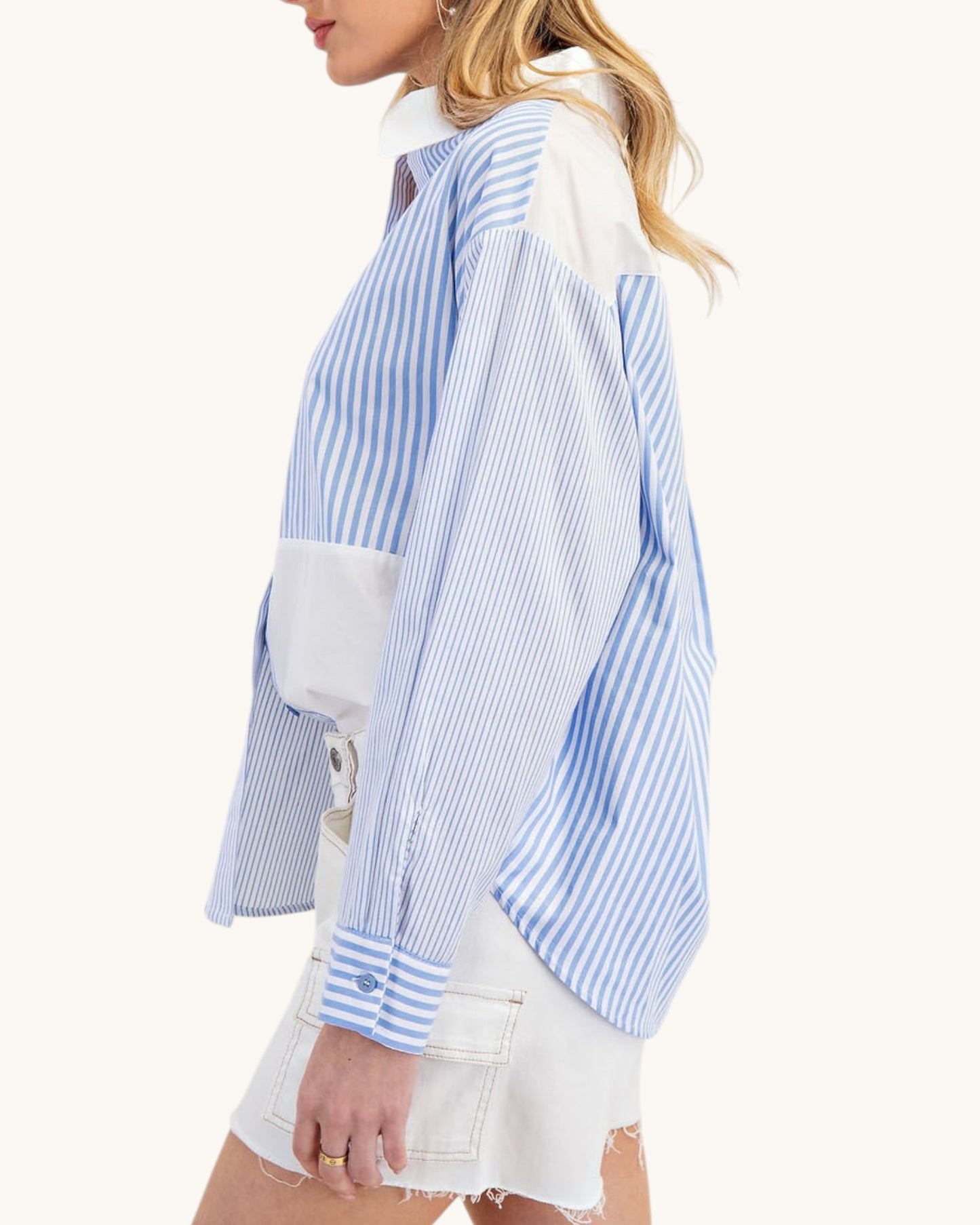 Woman wearing a blue and white striped shirt with a white background.