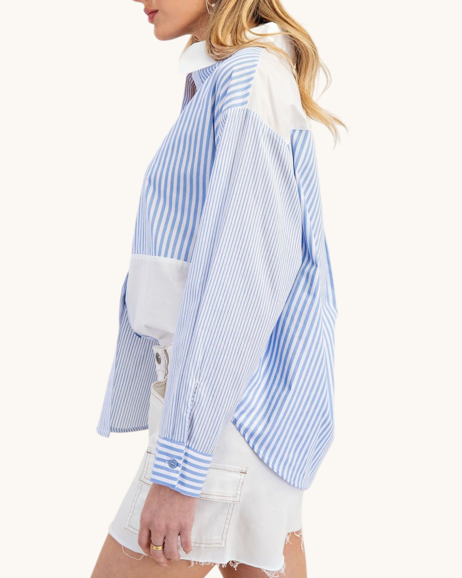 Woman wearing a blue and white striped shirt with a white background.