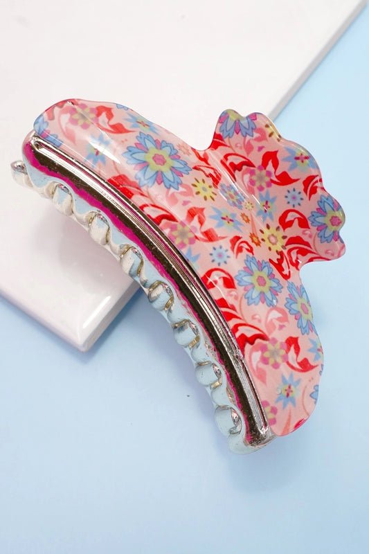 Floral paisley patterned hair clip on a light blue background.