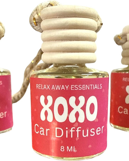 XOXO Car Diffuser with pink label and wooden diffuser on a white background.