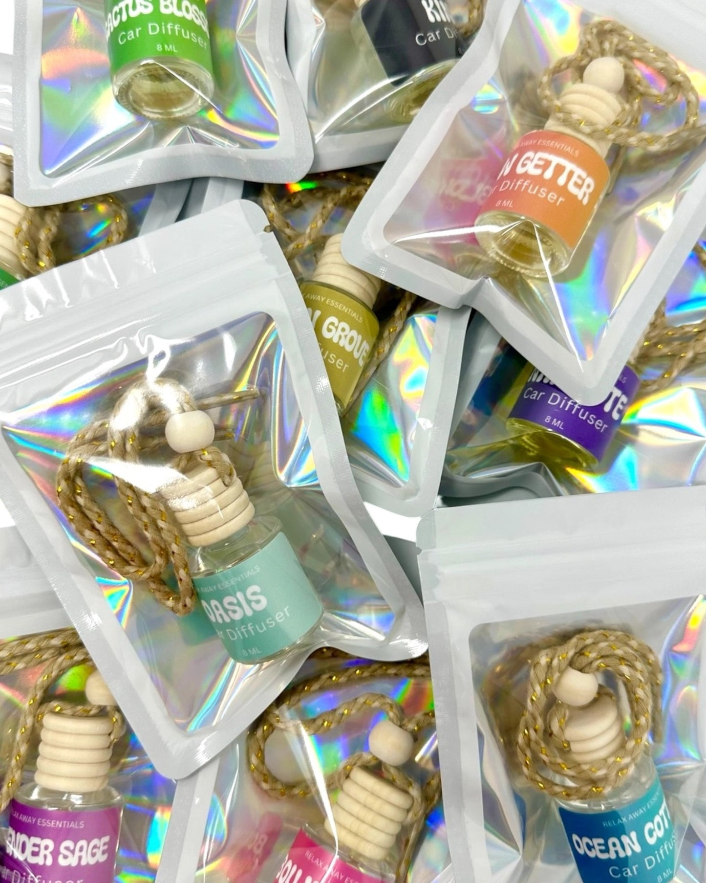Collection of small essential oil diffusers in clear packaging with colorful labels.