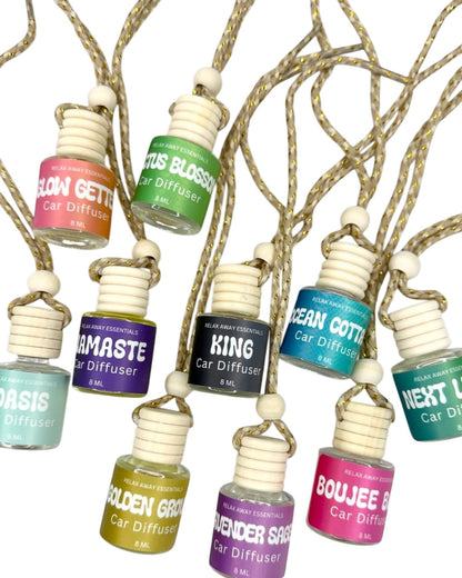 Collection of car diffuser bottles with colorful labels on a white background.