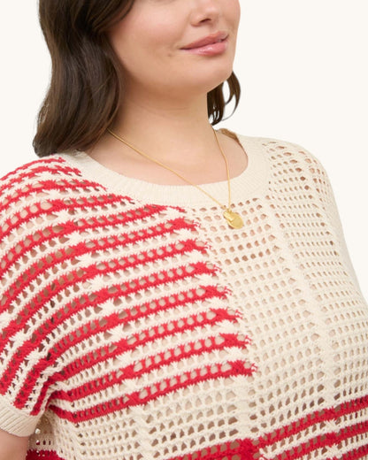 Detail shot of red and cream open knit crochet top. 