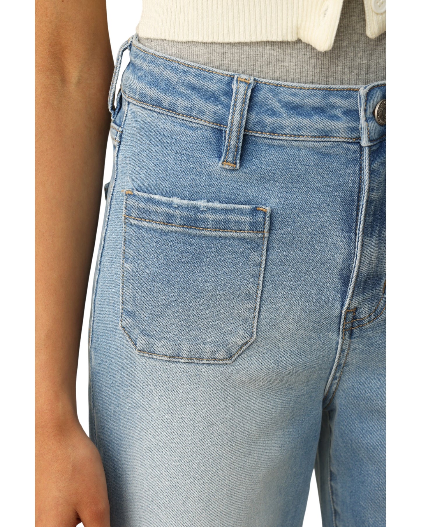 Close-up of light blue jeans with a focus on the pocket area.