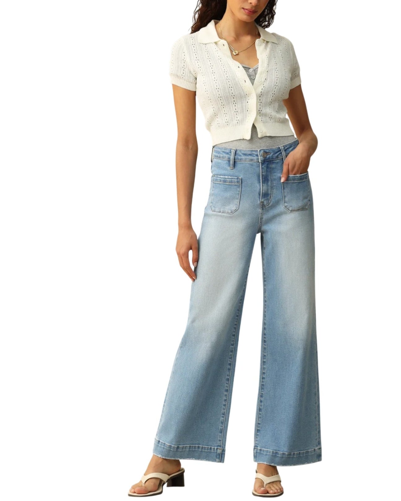 Woman wearing light blue jeans and a white top on a white background