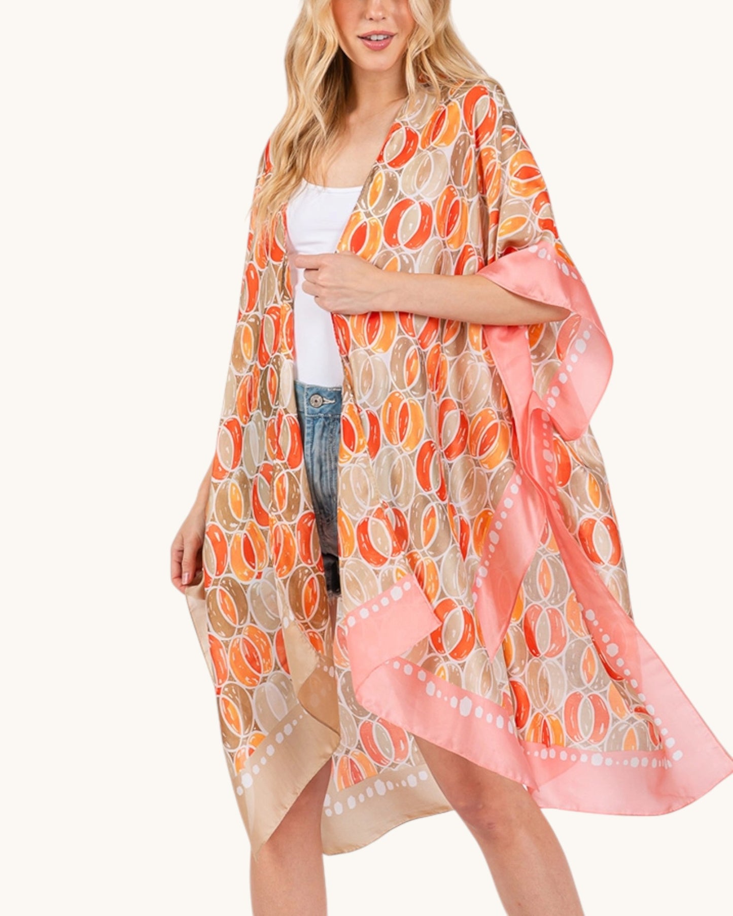 Woman wearing a colorful kimono-style garment with a white background.
