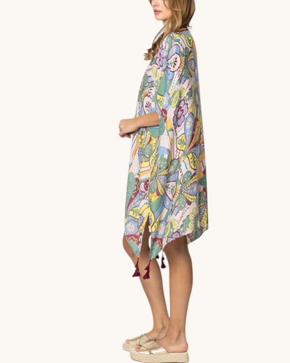 Woman wearing a colorful patterned cover up on a white background.