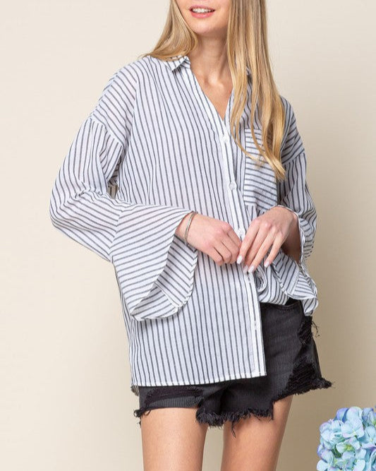 Woman wearing a striped shirt and black shorts against a beige background