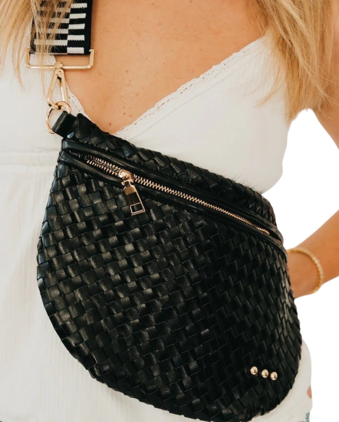 Black woven bum bag by a person on a white background.