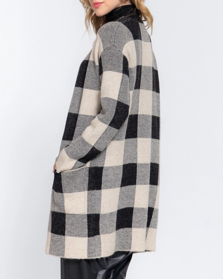 Woman wearing a black and white checkered coat on a white background.