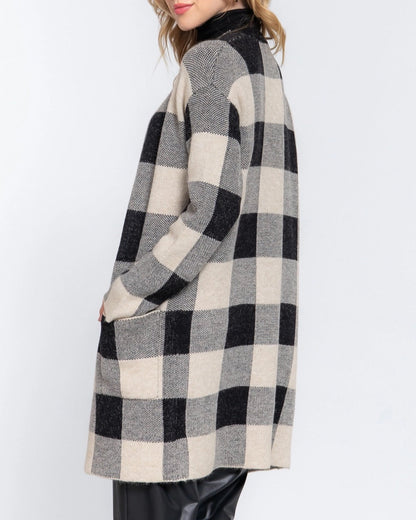 Woman wearing a black and white checkered coat on a white background.