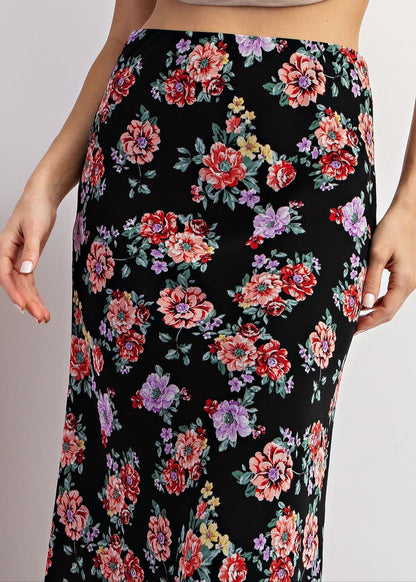 Black floral maxi skirt with red and purple blooms and A-line silhouette. 