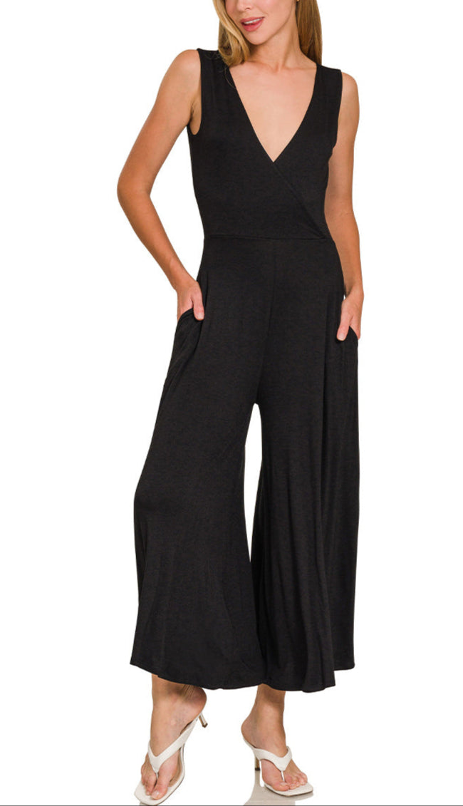 Woman wearing a black sleeveless wide-leg jumpsuit with a deep V neckline.