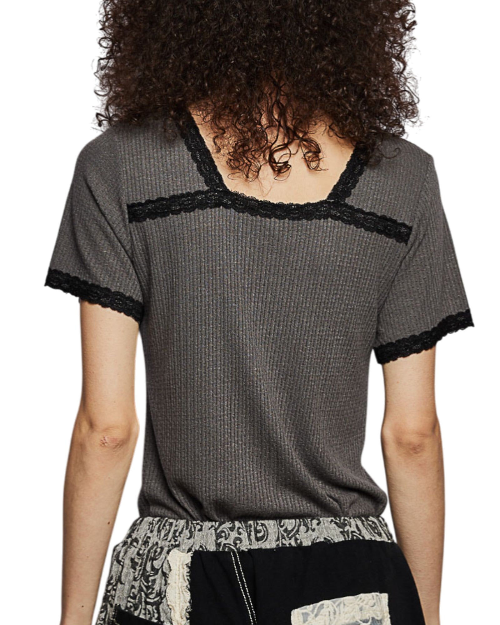 Person wearing a gray short-sleeve top with black trim on a white background