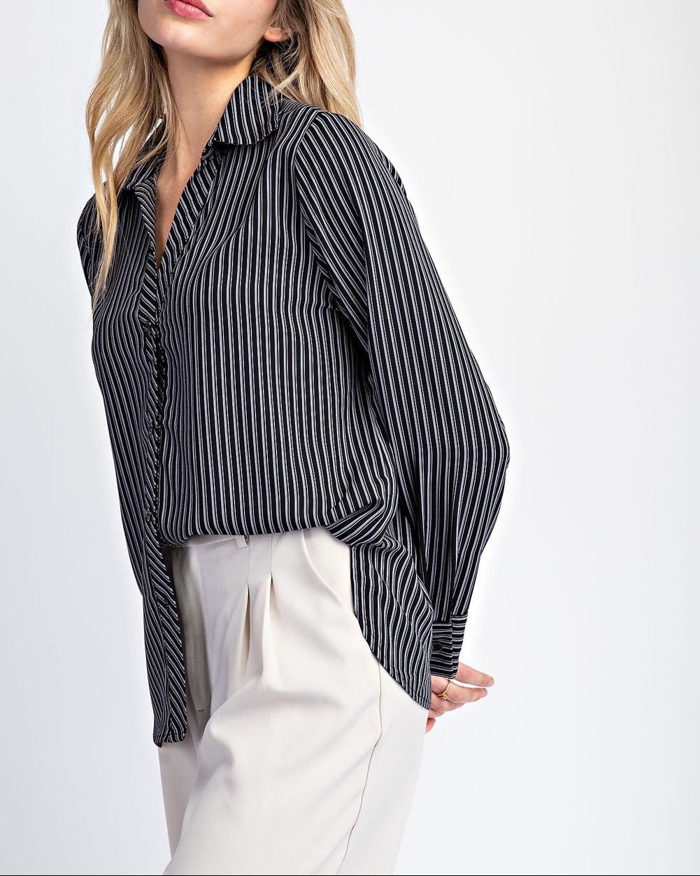 Woman wearing a black and white striped shirt on a white background.