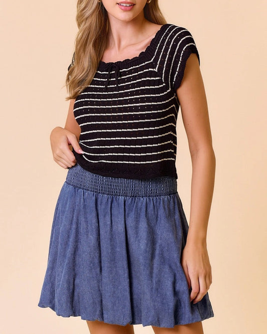 Woman wearing vintage-inspired black and tan crochet stripe top with square neckline and a denim skirt.