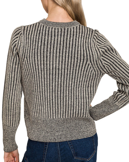 Woman wearing a charcoal ribbed zip up sweater and blue jeans on a white background.