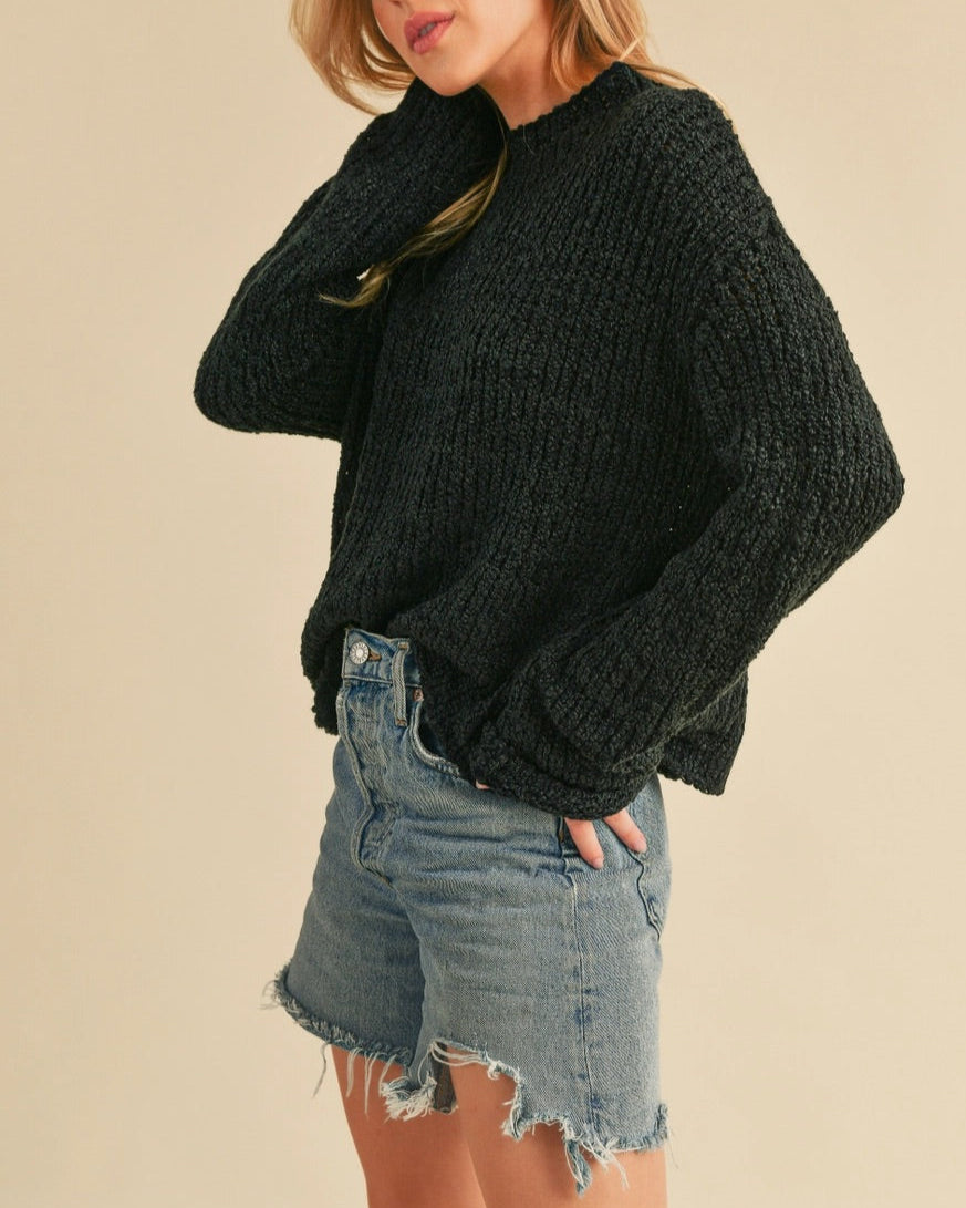 Black textured mock neck sweater with boxy relaxed fit.