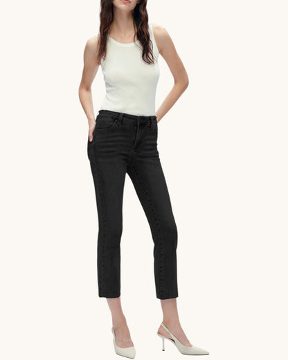 Woman wearing a white sleeveless top and black pants on a white background.