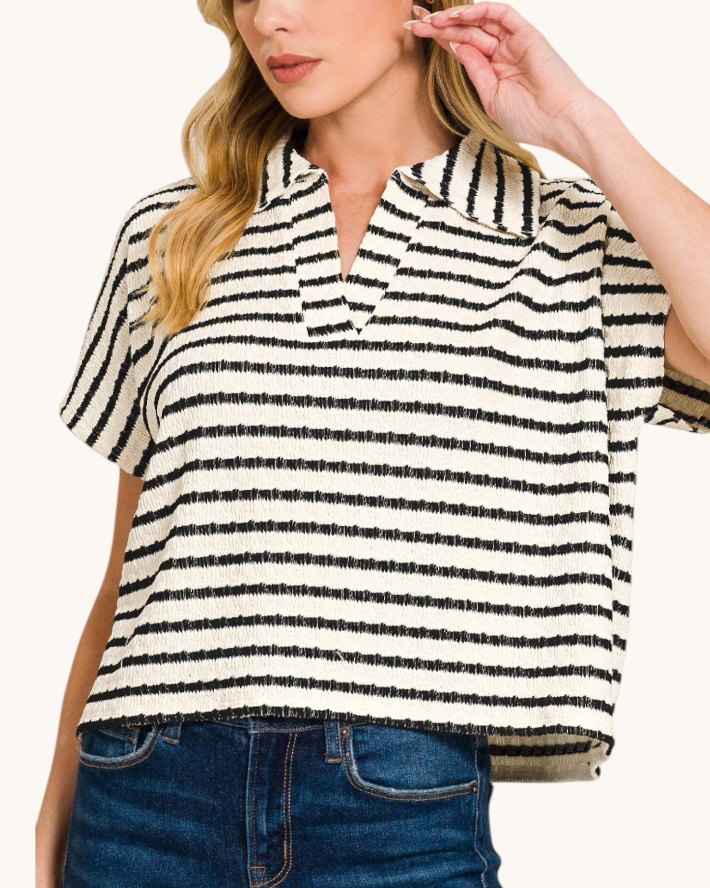 Woman wearing a black and white striped shirt with short sleeves.