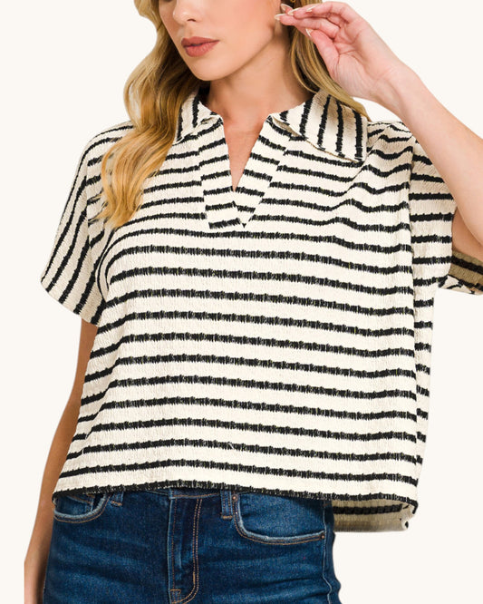 Woman wearing a black and white striped shirt with short sleeves.