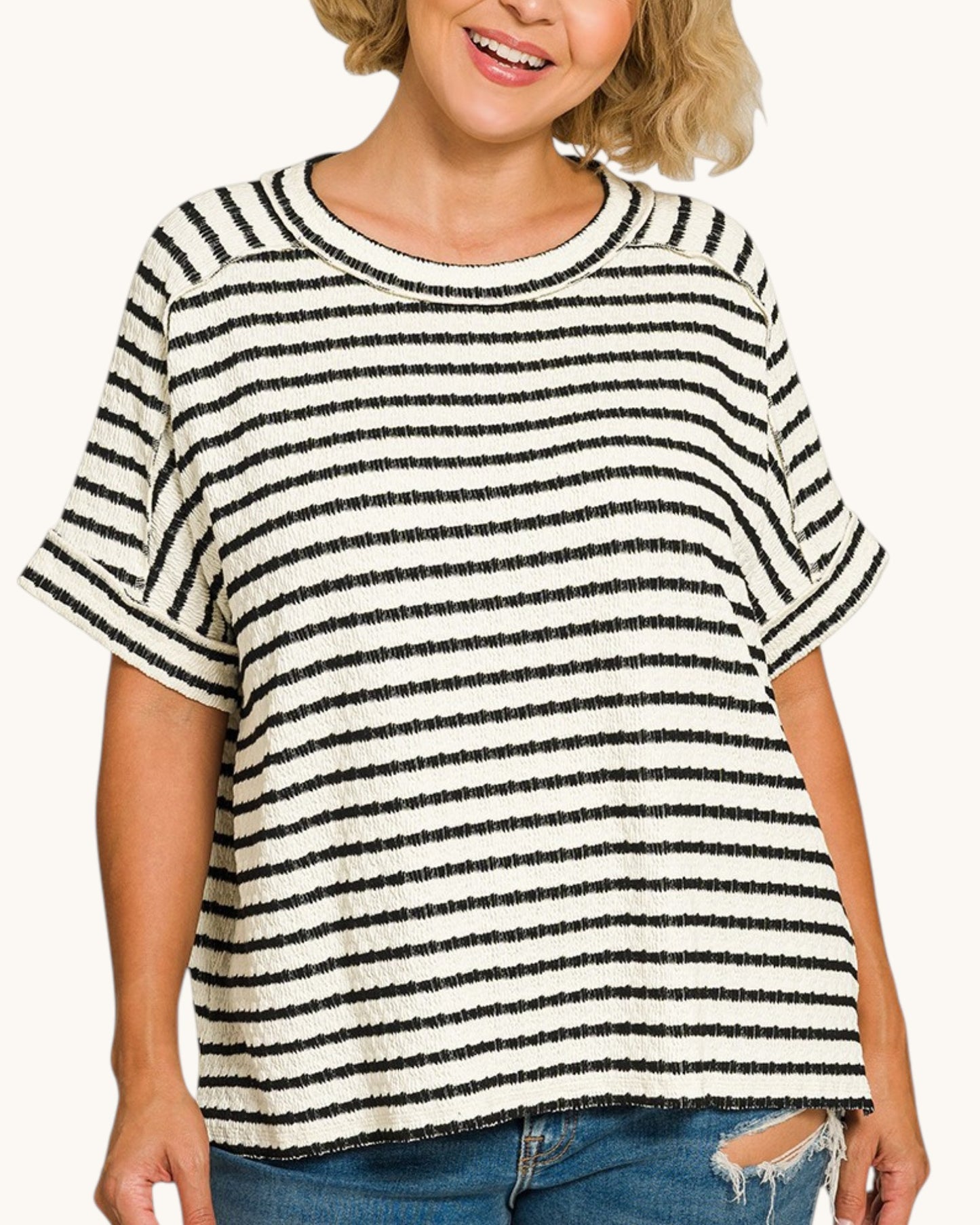 Woman wearing a black and white striped shirt with a white background.