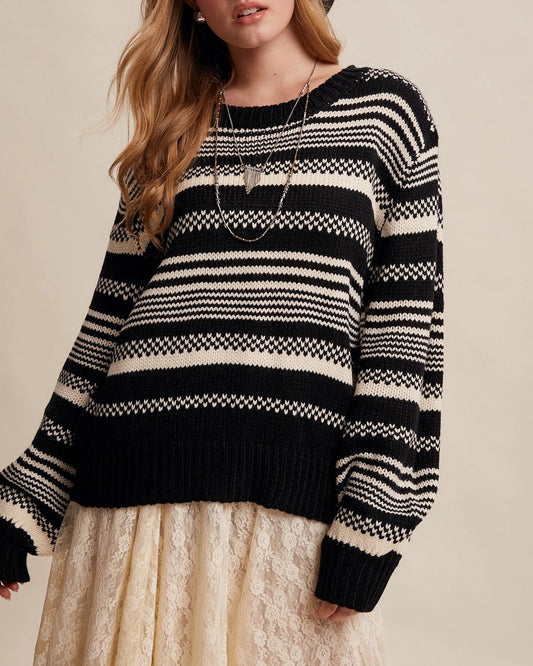 Woman wearing Black and ivory Fair Isle inspired striped sweater with relaxed fit and ribbed trim.