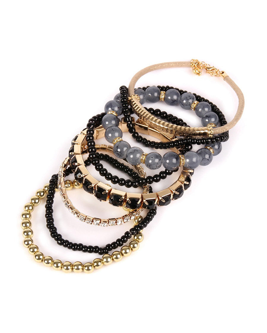 Set of beaded bracelets in black, gold, and gray on a white background.