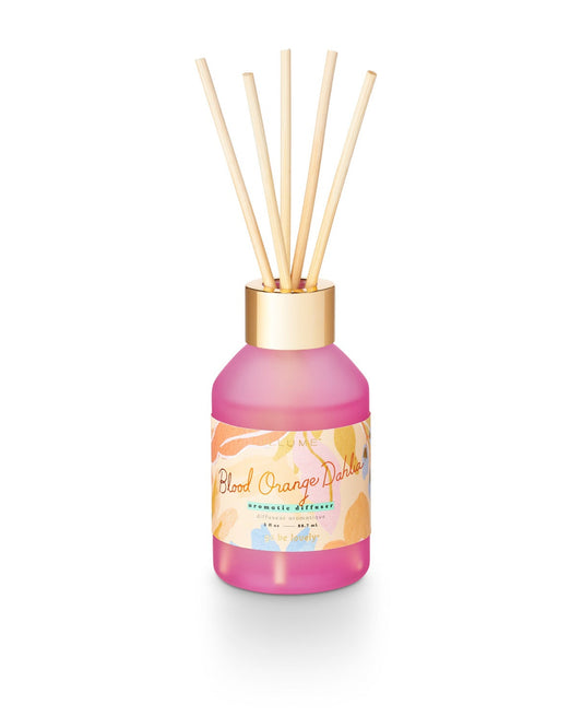 Pink diffuser bottle with wooden sticks on a white background.