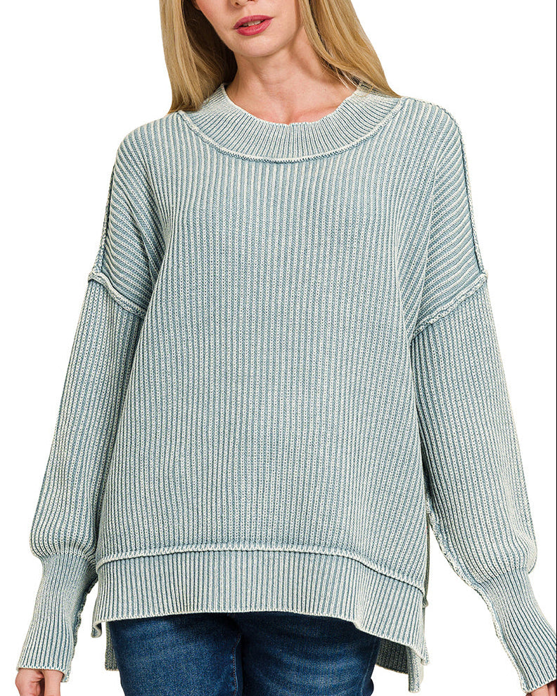 Woman wearing a blue-grey sweater on a white background.