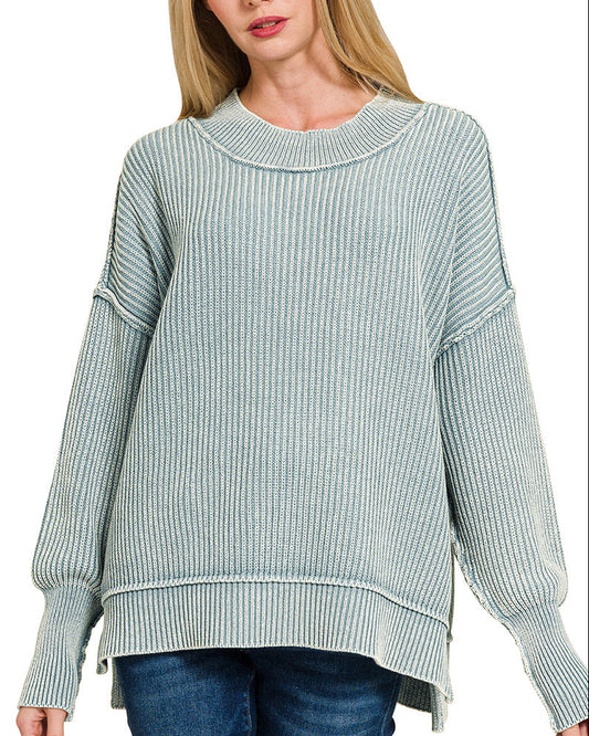 Woman wearing a blue-grey sweater on a white background.
