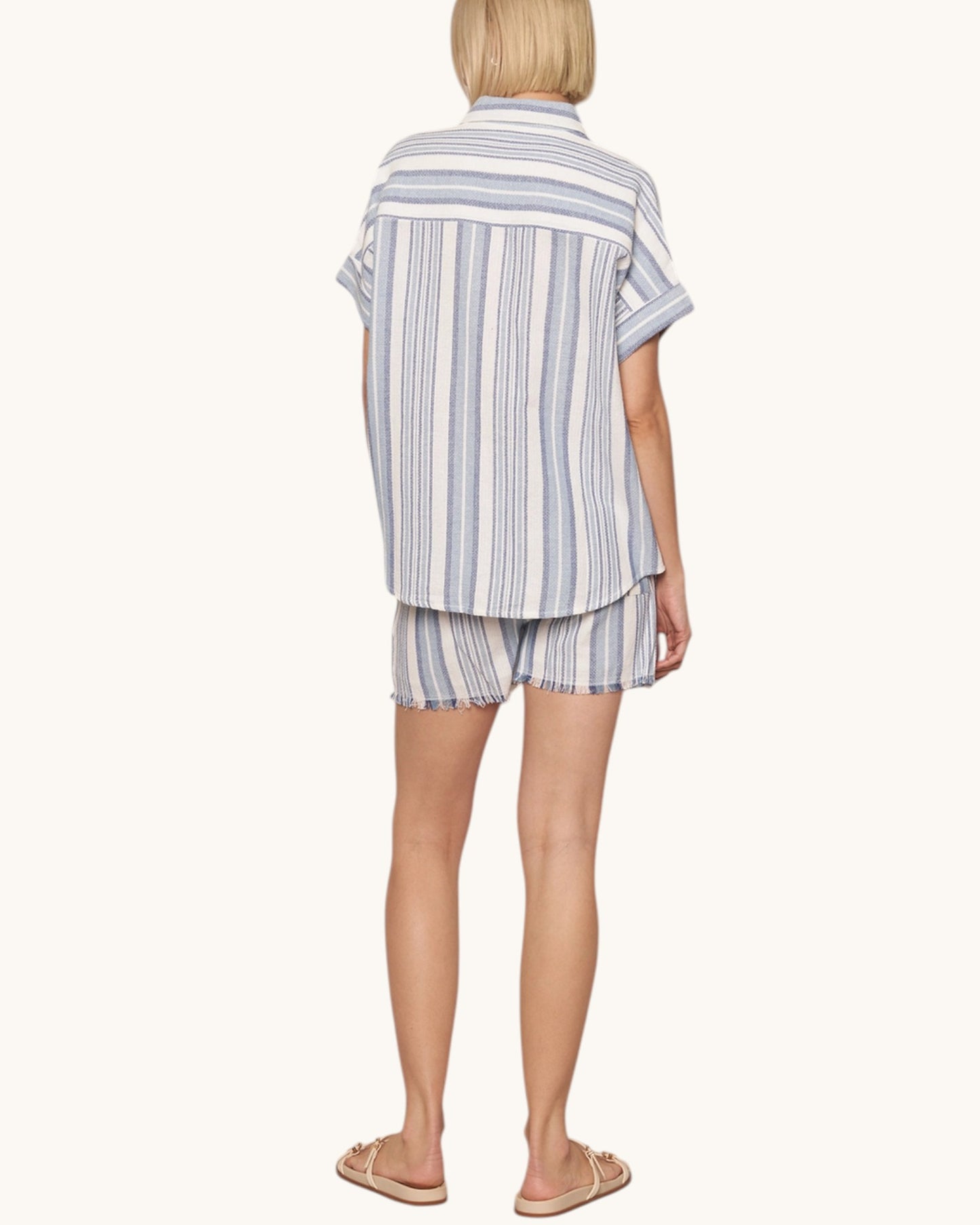 Person wearing a striped shirt and shorts set on a white background.