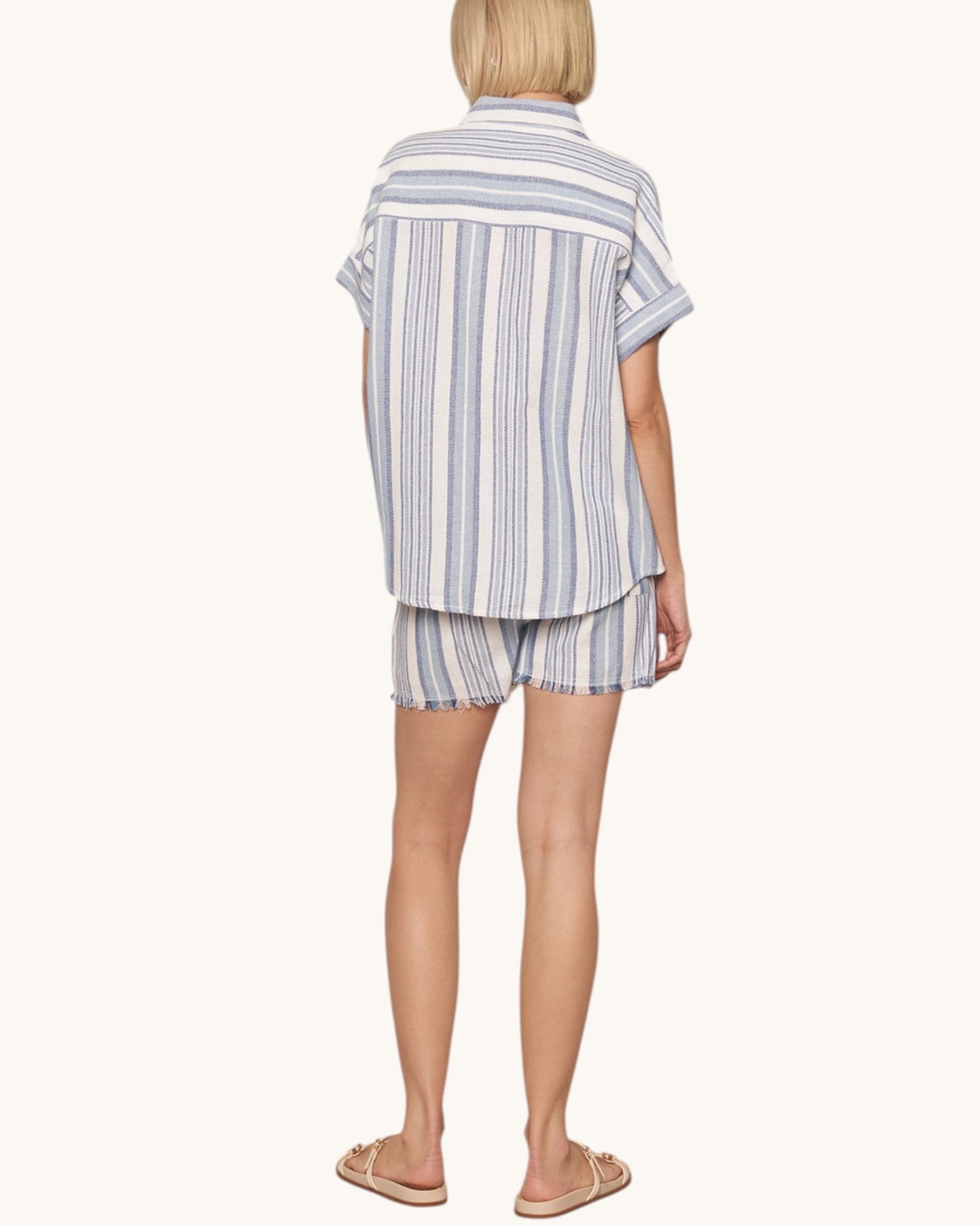 Person wearing a striped shirt and shorts set on a white background.