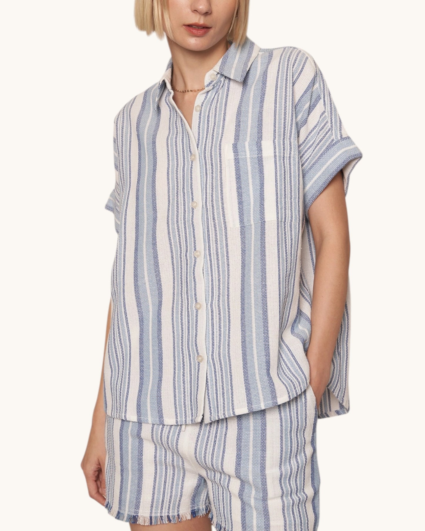 Woman wearing a blue and white striped shirt and shorts set on a white background. Shop the By the Sea Striped Cotton Top & Shorts Set.