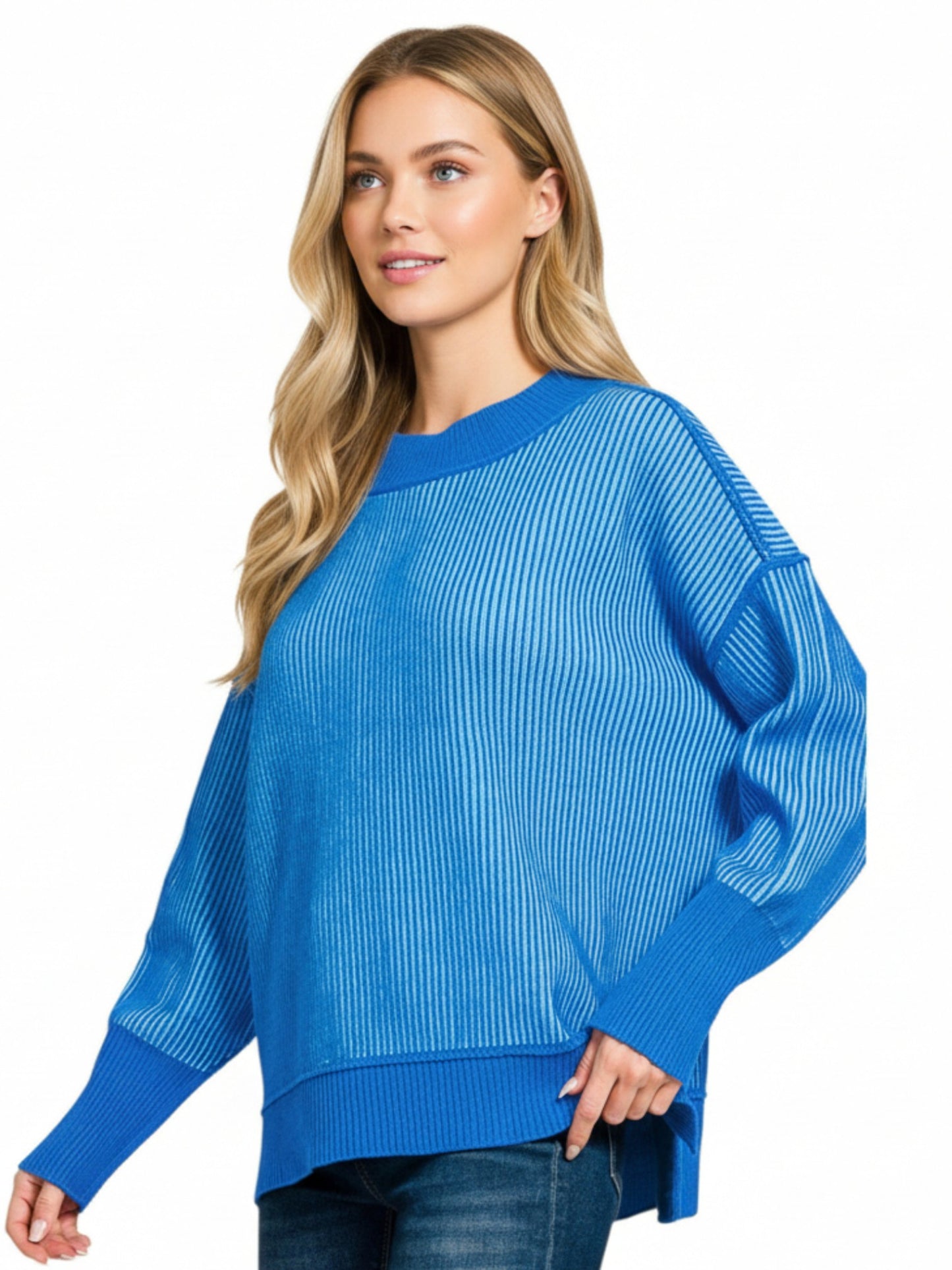Woman wearing a blue ribbed sweater on a white background.