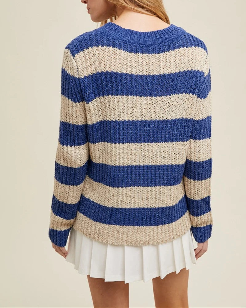 Person wearing a blue and beige striped sweater on a beige background.