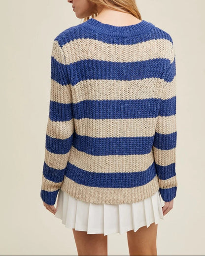 Person wearing a blue and beige striped sweater on a beige background.