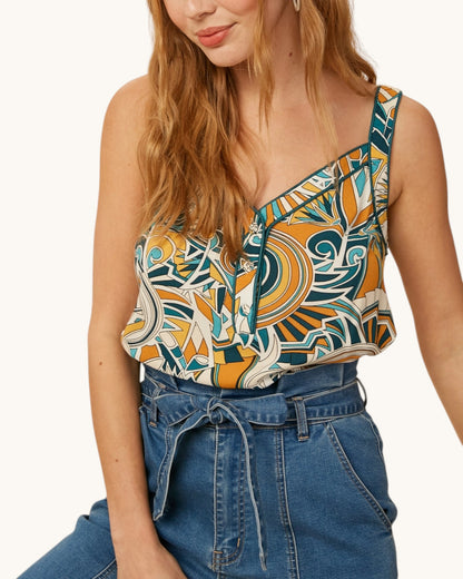 Woman wearing a patterned boho top and blue jeans on a white background.